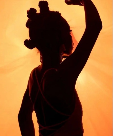 Model wearing a handmade crochet piece in warm studio light